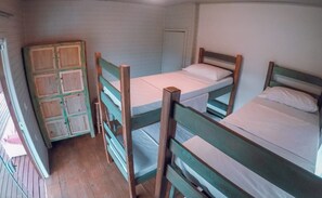 A dormitory room with bunk beds, a wooden wardrobe, and a door. - Franca's House - Piscina - Praia do Rosa (Imbituba)