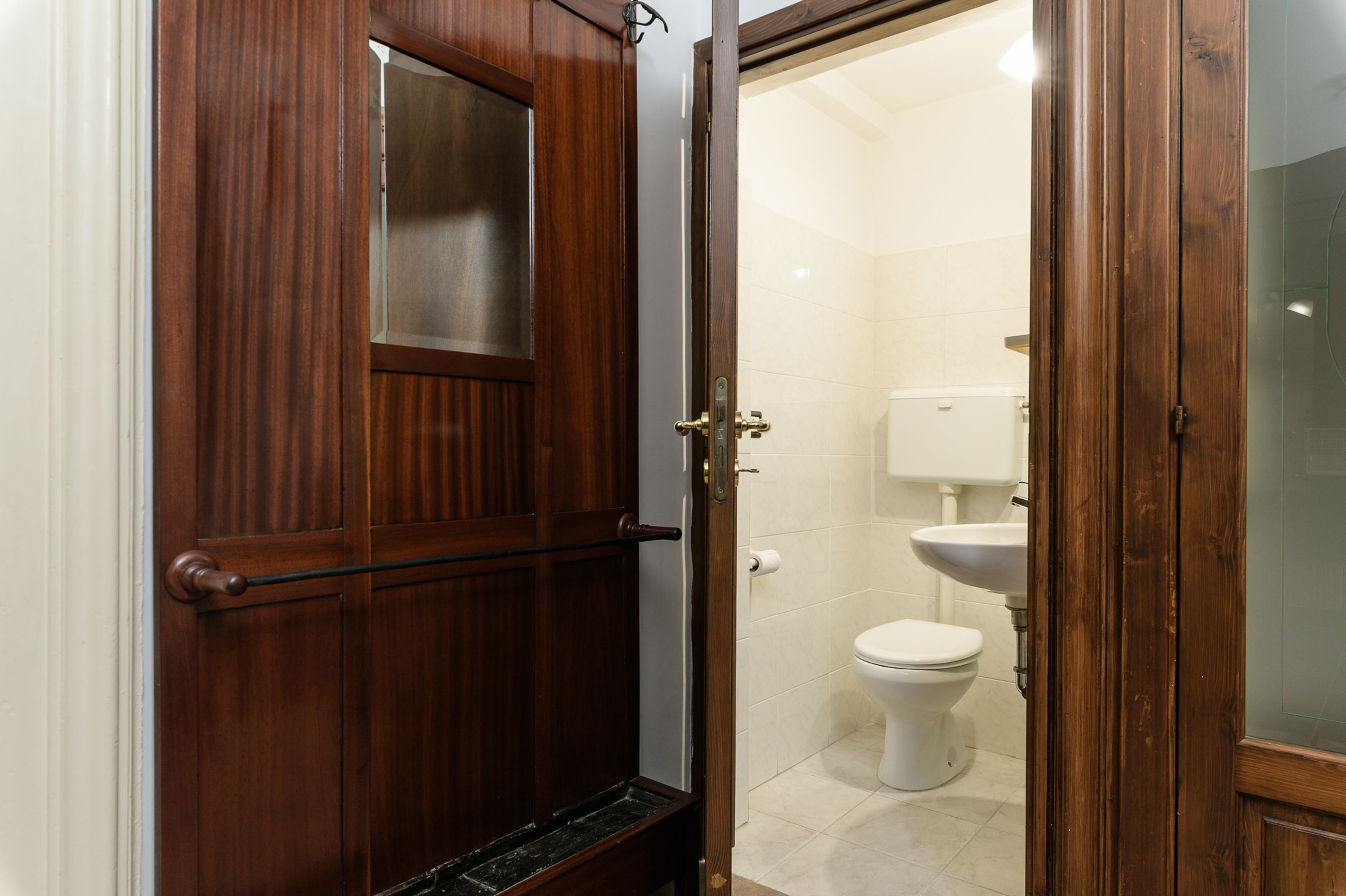 Una puerta de madera con un panel de vidrio y un pomo de metal.