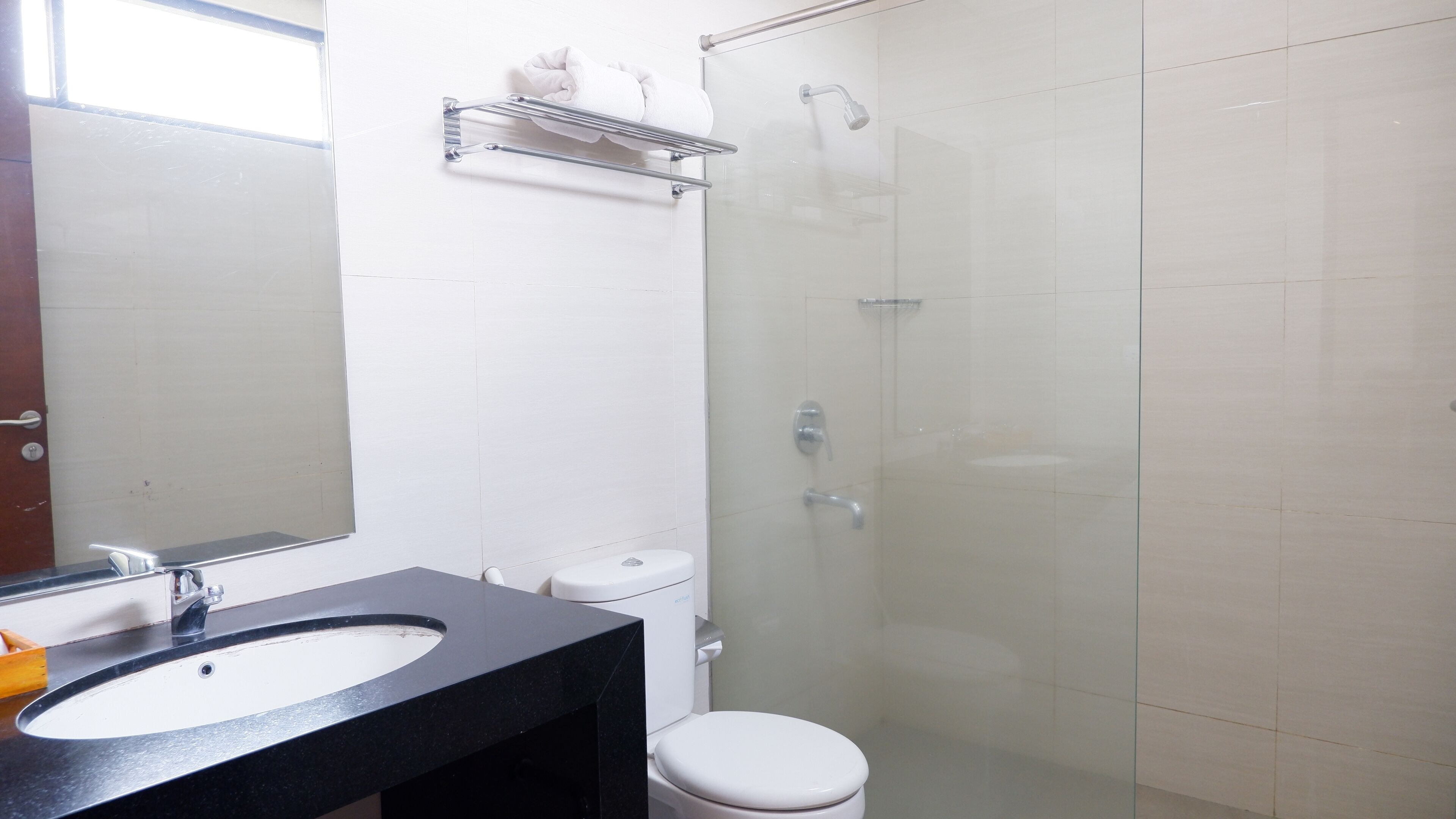 A bathroom with a sink, toilet, and glass shower enclosure.