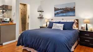 Une chambre avec un grand lit, un bureau et une douche.