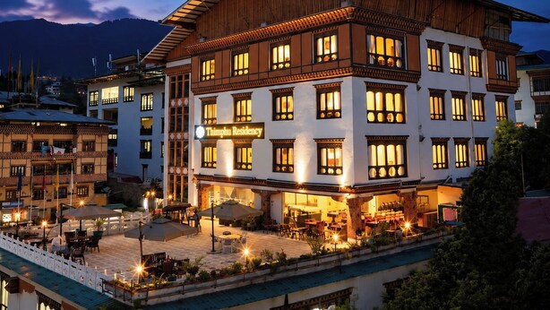 Un edificio de varios pisos con un cartel que dice 'Thimphu Residency'.