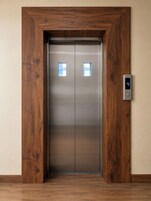 Un ascensore moderno con struttura in legno e display digitale che indica il numero 4.