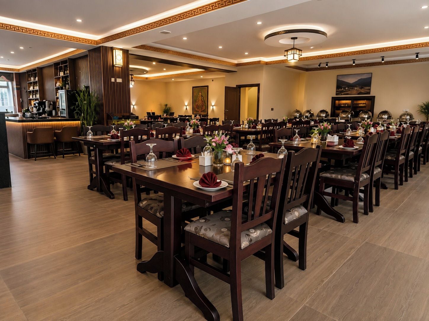 A formal dining area with multiple tables and chairs, a bar area, and a well-lit ceiling with recessed lighting.