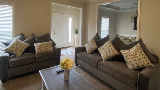 A living room with two sofas, a coffee table, and a ceiling fan. - Classic connection in the Hub City! (Jackson)