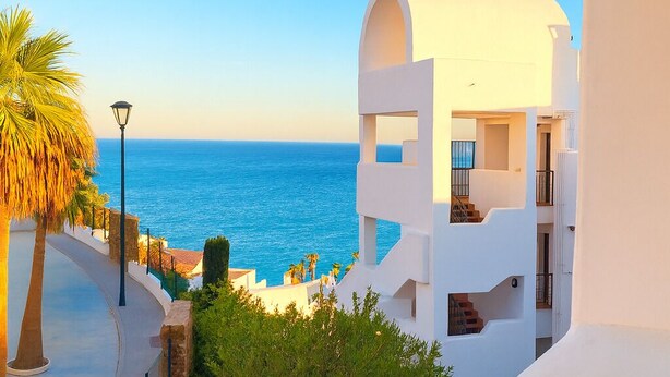 Un bâtiment moderne, de couleur blanche, doté d’un balcon offrant une vue sur la côte.