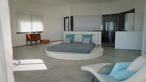 A modern bedroom with a circular bed, a wooden dresser, and a small table. - 8 Bedroom Villa in tomino (tomino)