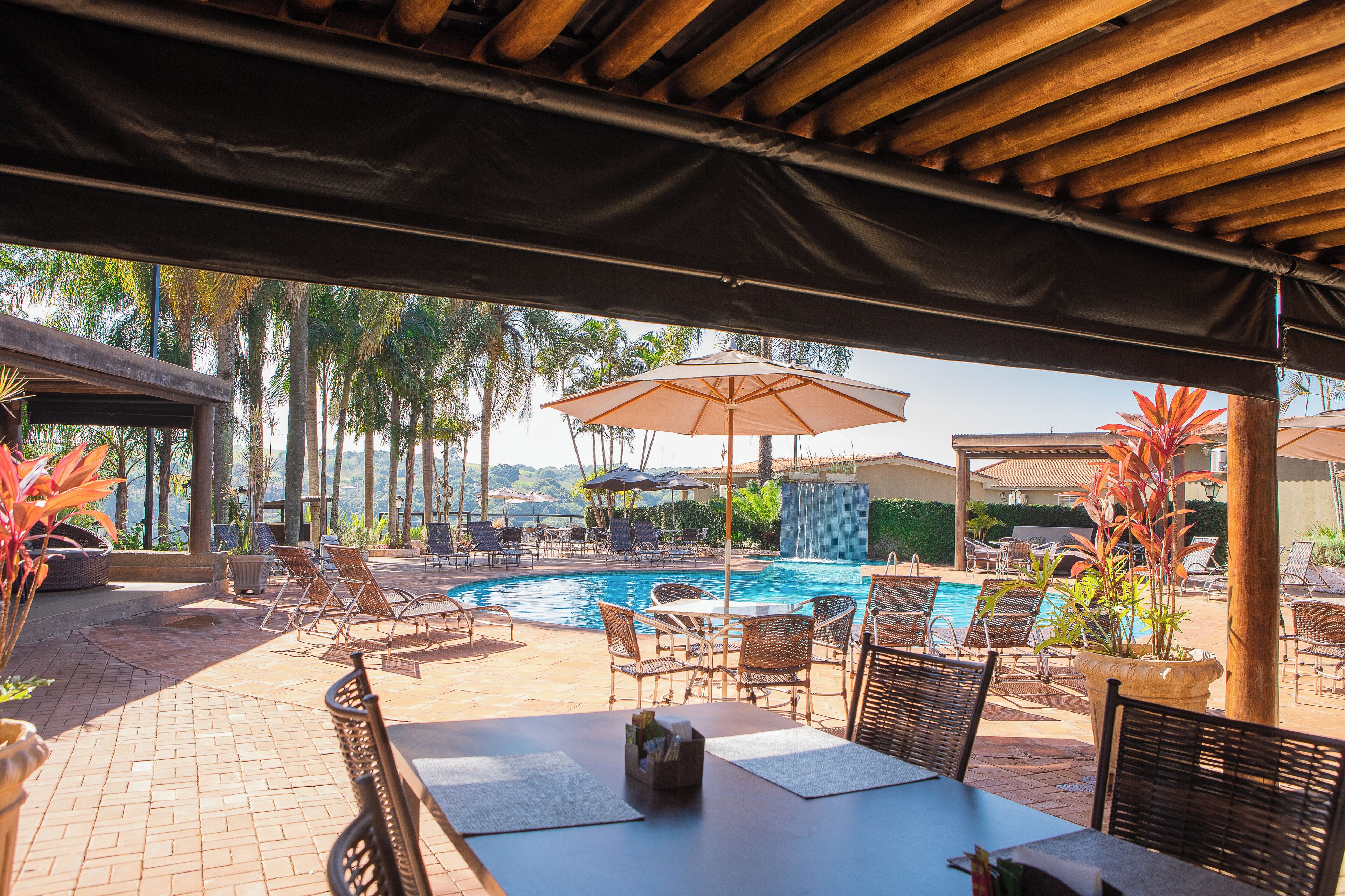A poolside area with lounge chairs, umbrellas, and a view of the pool.
