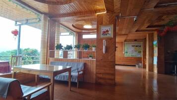 Un interno in legno con zona pranzo, posti a sedere e vista dalla finestra.