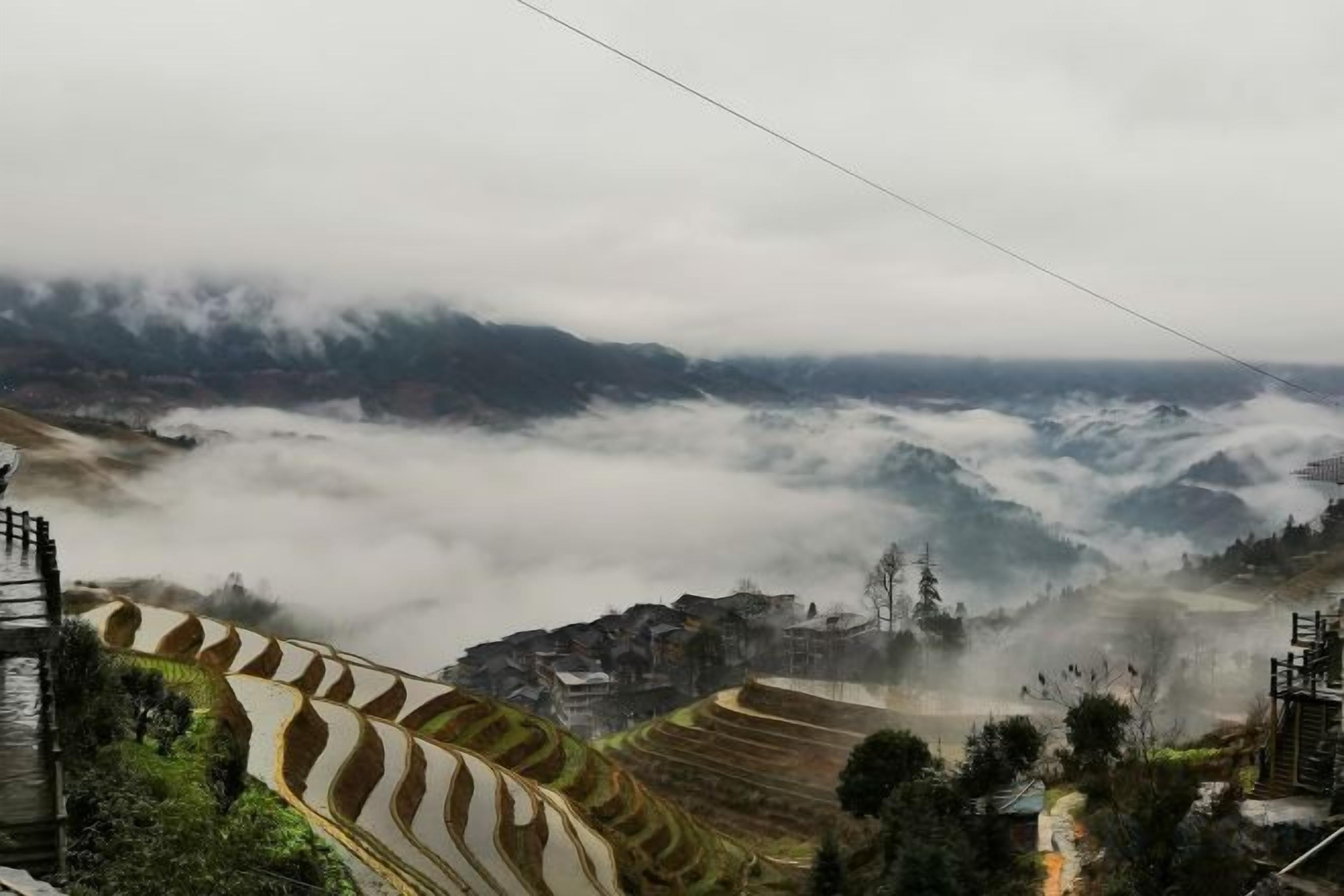 Terraced fields, a power line, and a village in the valley.
