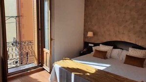 A bedroom with a bed, a nightstand, a lamp, and a view through a door to an outdoor balcony. - UTE Hotel Villa de Biar (Biar)