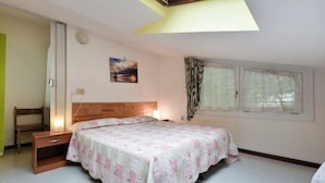 A bedroom with a bed, bedside table, and a window with curtains. - Lido di Jesolo, Italy. Entire accommodation (Lido di Jesolo)