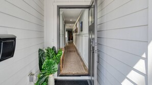 A hallway with a door leading to a room, a small plant, and a mailbox. - Lincolnville Nook (St. Augustine)