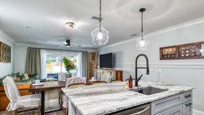 A modern kitchen with a marble countertop, stainless steel appliances, and pendant lighting. - Lincolnville Nook (St. Augustine)