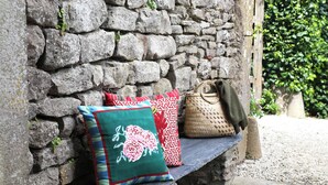 A stone bench with three cushions and a woven bag against a stone wall. - Minori - 2 Bedroom - Private Terrace - Amazing View (Villarzel-Cabardès)