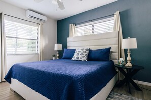 A bedroom with a bed, two bedside tables, a ceiling fan, and an air conditioning unit. - One bedroom private apt 2 blocks to beach (Pompano Beach)