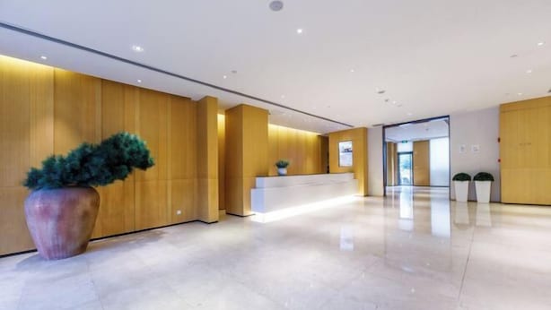 A modern hotel lobby with a reception desk, a large potted plant, and a clean, polished floor. - JI Hotel (Shanghai Hongqiao National Exhibition and Convention Center) (Shanghai)