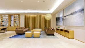 A modern lobby with a seating area, bookshelves, and artwork. - JI Hotel (Shanghai Hongqiao National Exhibition and Convention Center) (Shanghai)