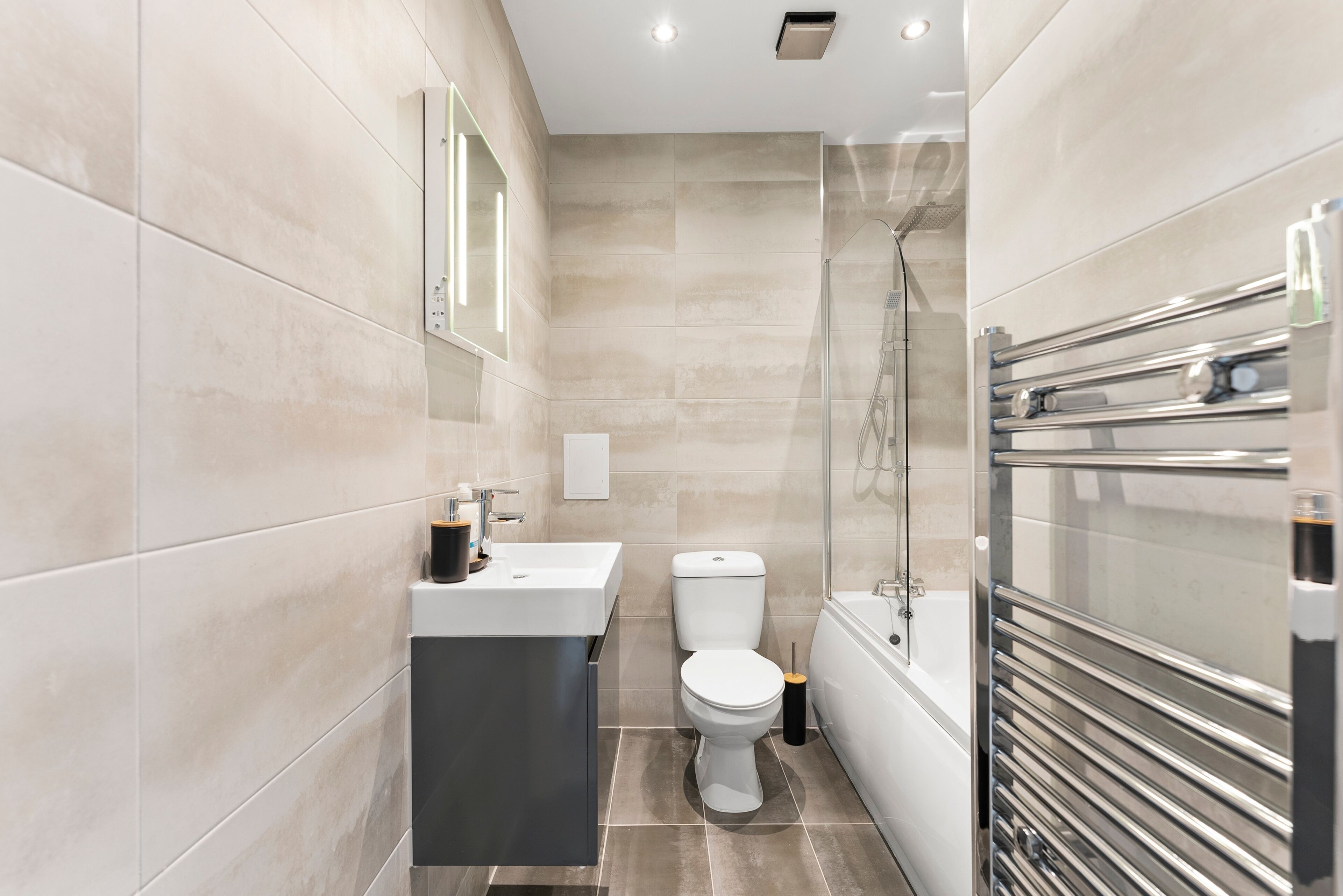 A modern bathroom with a shower, toilet, and sink.