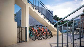Una escalera con barandilla de metal y varios objetos similares a bicicletas estacionadas abajo.