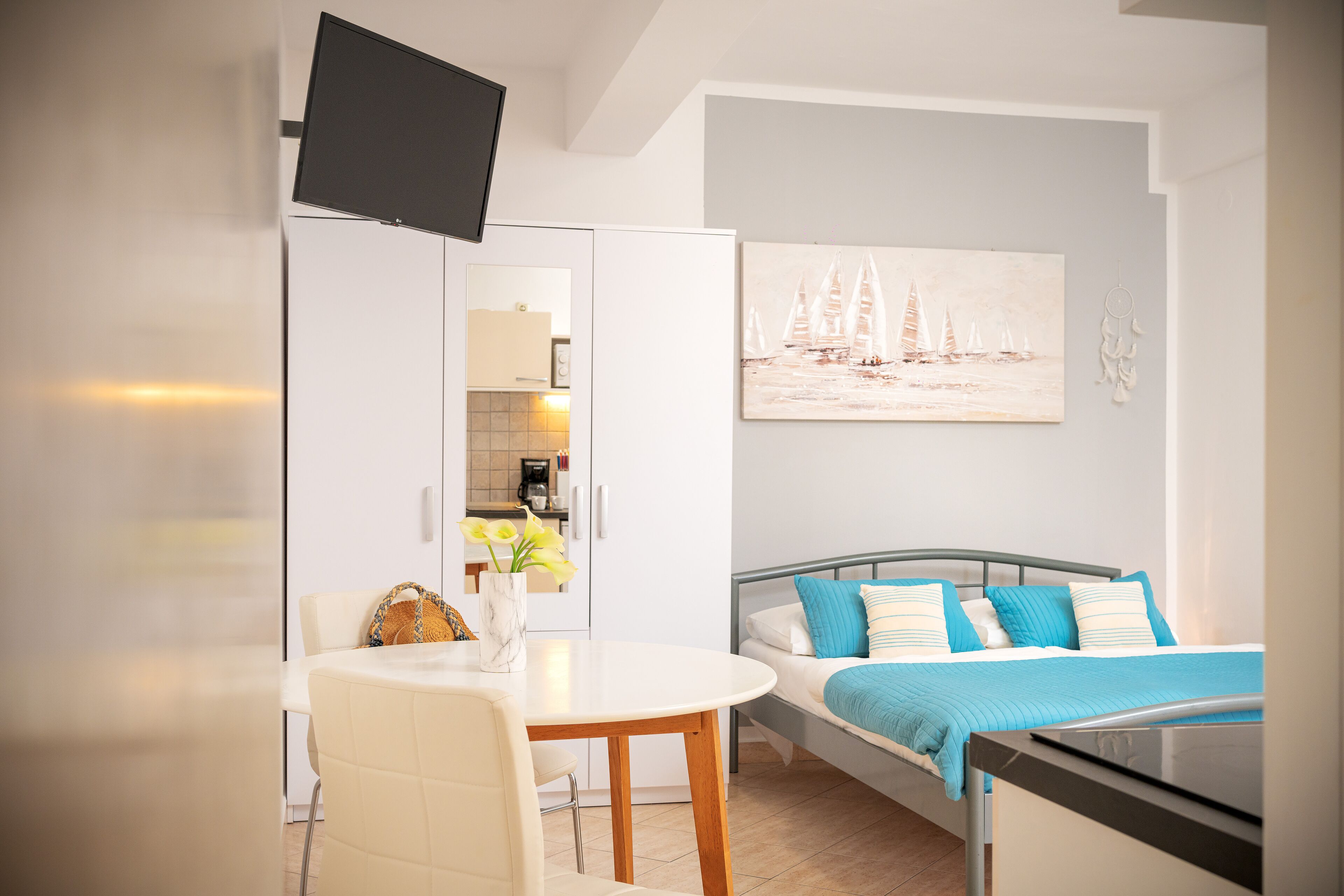 Ein modernes Schlafzimmer mit einem Bett, einem Nachttisch und einem Bild von Segelbooten.