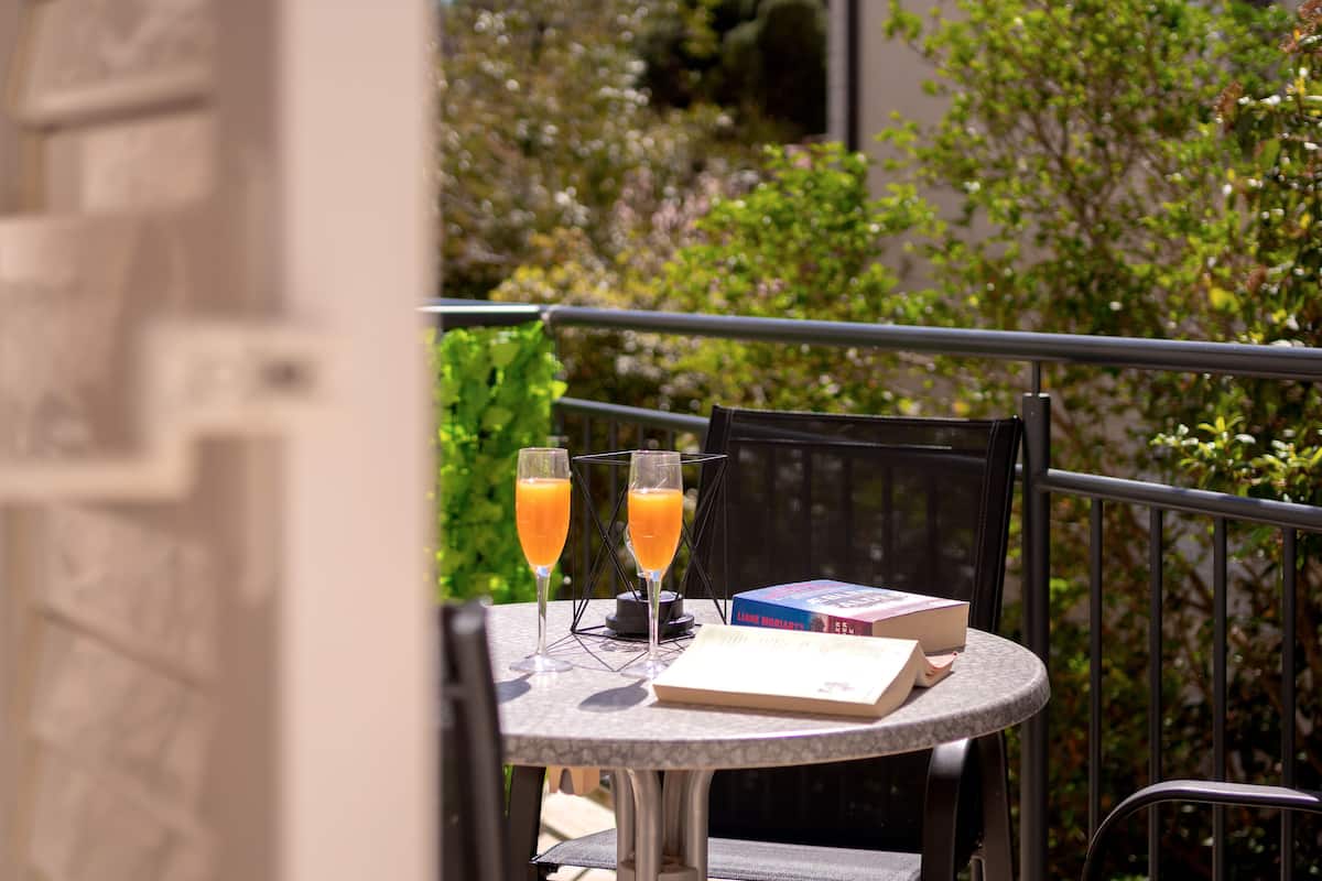 A round table with two glasses of orange juice, a book, and a menu.