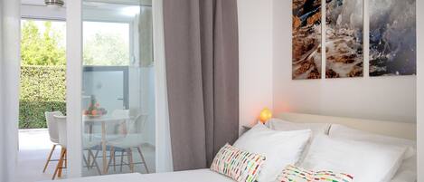 Una habitación de hotel con una cama grande, un escritorio con sillas y vistas al exterior.