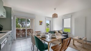 Et moderne køkken med spiseplads, en sofa og udsigt til det fri.