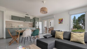 Et moderne køkken med spiseplads, sofa og stort vindue.