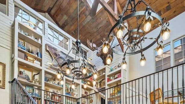 A multi-level interior with a staircase, wooden ceiling, and a chandelier.