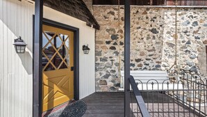 A wooden door with a yellow handle, a stone wall, and a metal bench. - Quaint walkable to Downtown Cashmere (Cashmere)