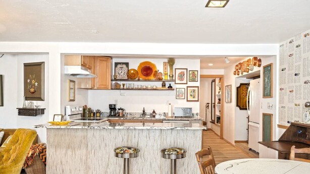 A modern kitchen with a central island, bar stools, and a dining area with a round table. - Quaint walkable to Downtown Cashmere (Cashmere)