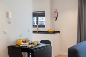 Enjoy a comfortable stay in this well-appointed room, featuring a breakfast table with a pitcher of juice, cereal, and croissants.