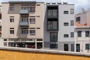Stylish residential building with balconies and windows, featuring a mix of architectural styles.