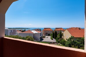 Ein Küstenwohngebiet mit Gebäuden, blauem Himmel und Blick auf das Meer.