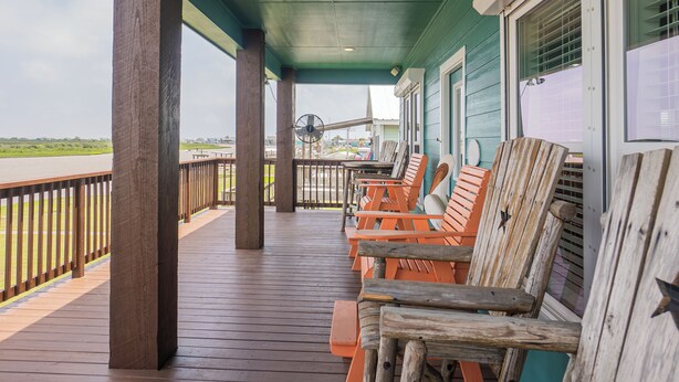 A covered outdoor seating area with wooden benches and a view of the beach. - Large Home Near the Caney Y with Pool! (Bay City)