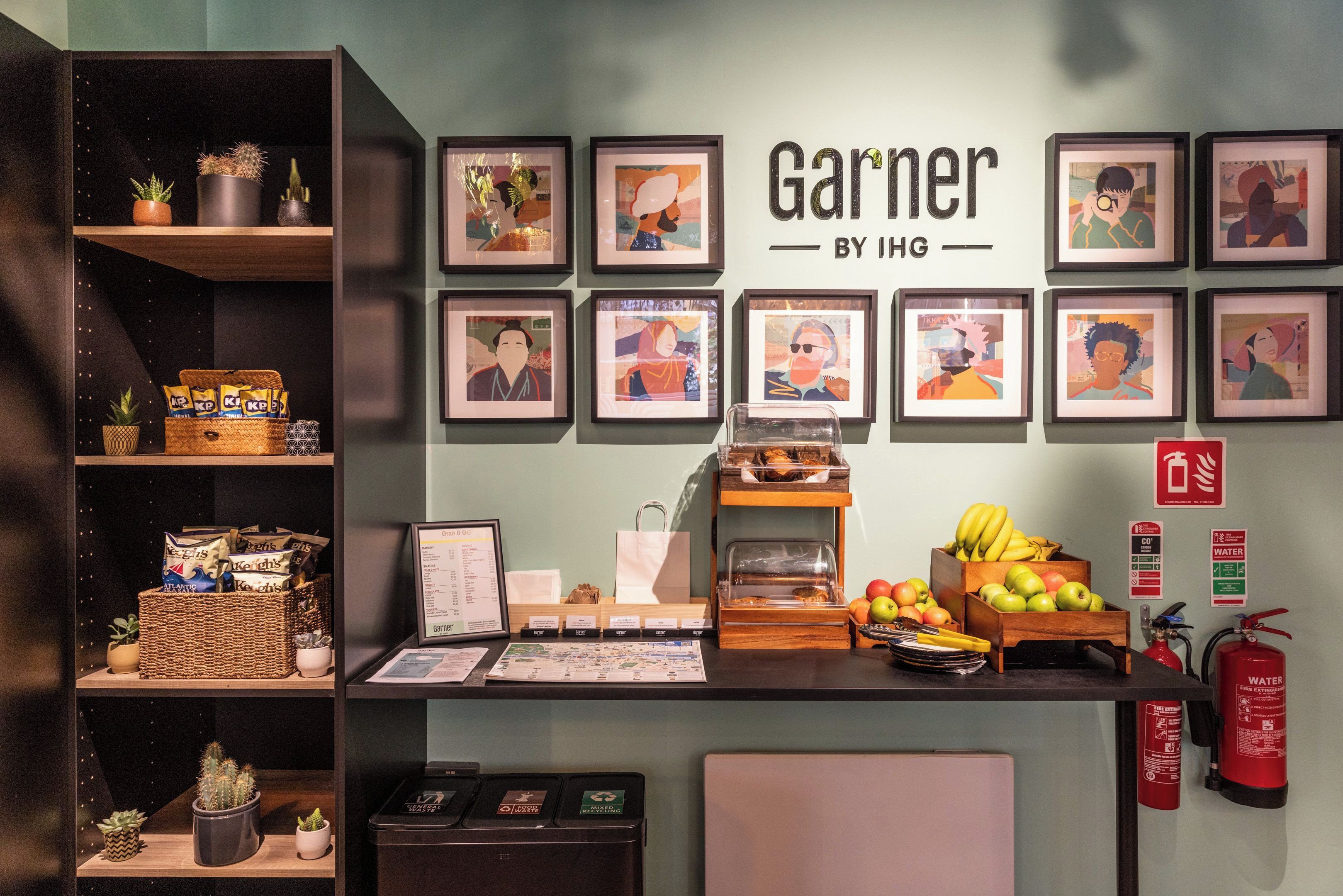 A counter with a menu, framed artwork, and a fire extinguisher.