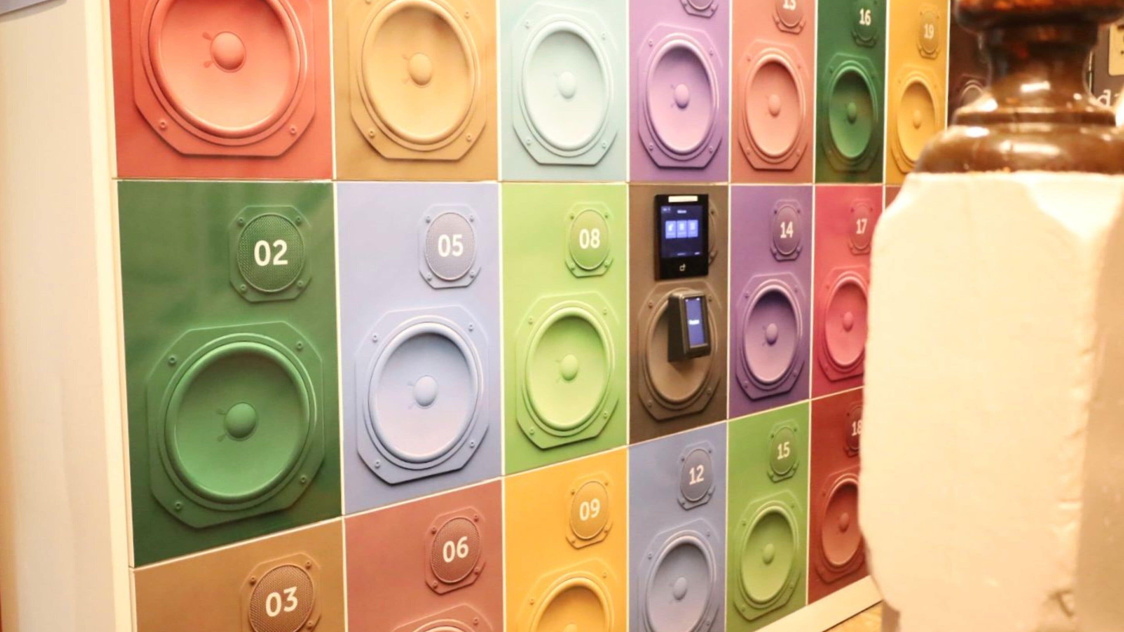 A wall with numbered panels, each with a speaker and a control panel.