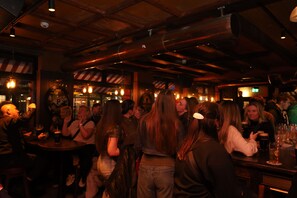 A crowded bar with wooden beams on the ceiling and patrons seated at tables. - Garner Hotel Dublin Temple Bar by IHG (Dublin)