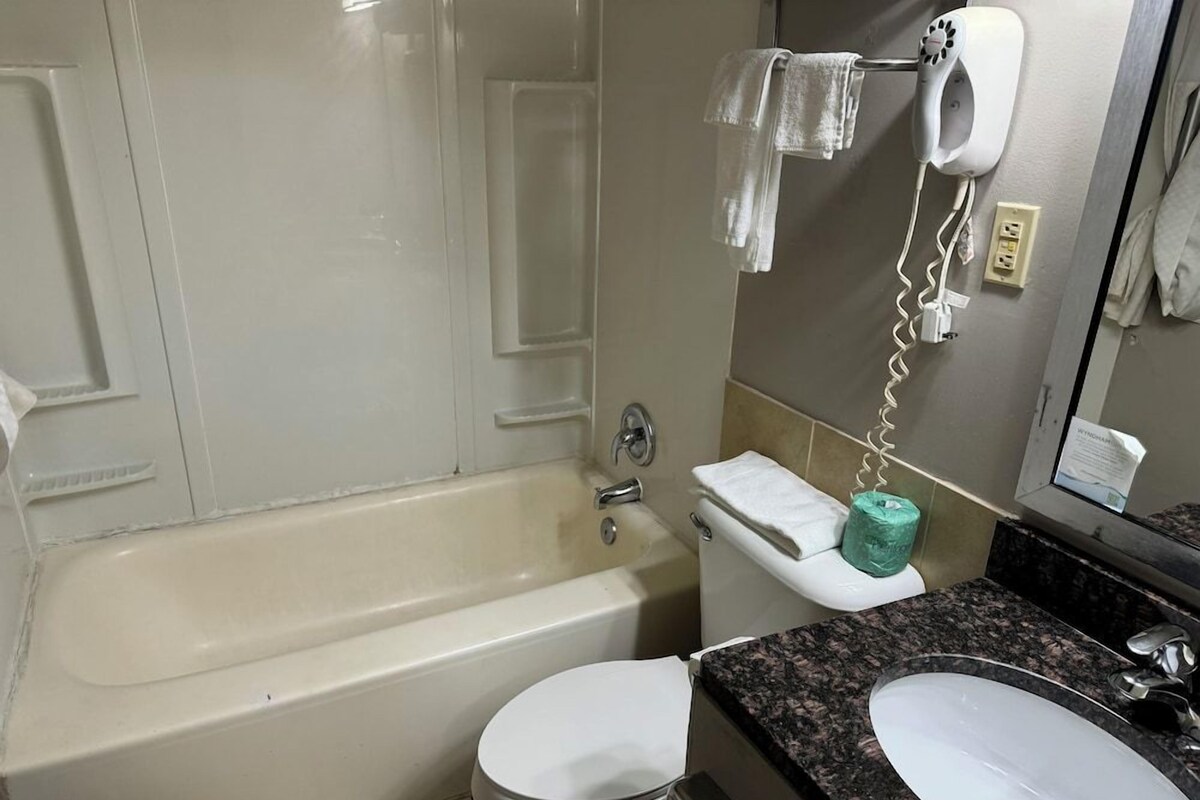 A bathroom with a bathtub, toilet, and sink.