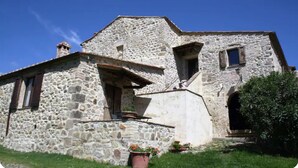 Un edificio de piedra con techo inclinado, una ventana pequeña y una puerta.
