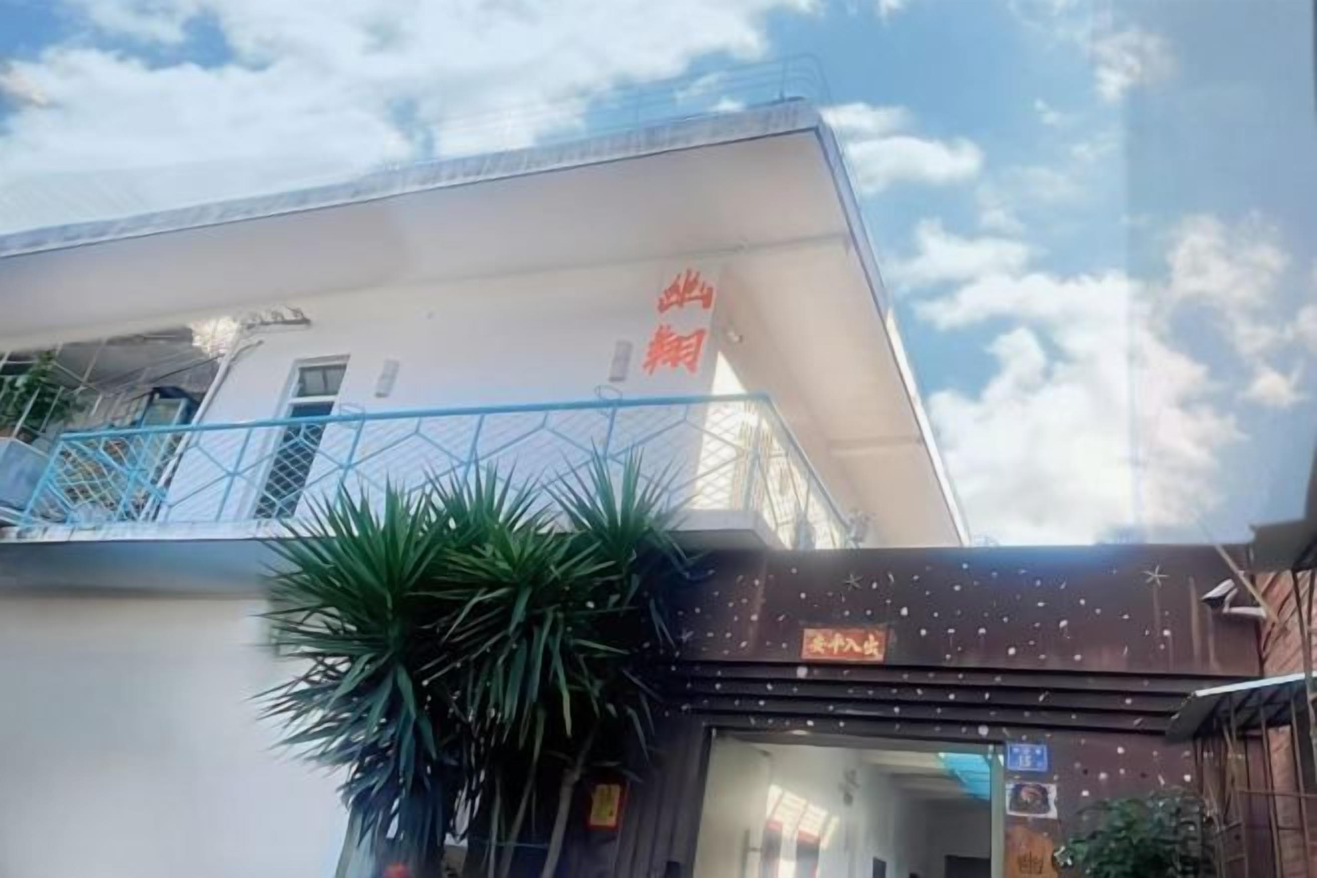 A building with a balcony and a sign with Chinese characters.