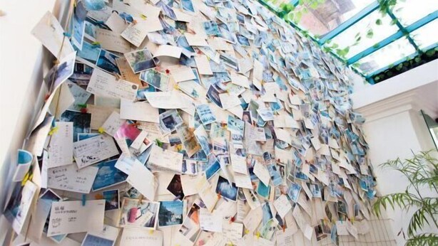 Eine Wand, die mit vielen Fotos und Notizen bedeckt ist.