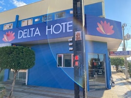 Un edificio con fachada azul y el nombre "DELTA HOTEL" bien visible.
