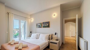 Ein Schlafzimmer mit einem Bett, Nachttischen, einer Lampe und einem Bild an der Wand.