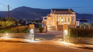 Un edificio tradicional con techo de tejas, entrada de piedra y un camino que lleva a la entrada principal.