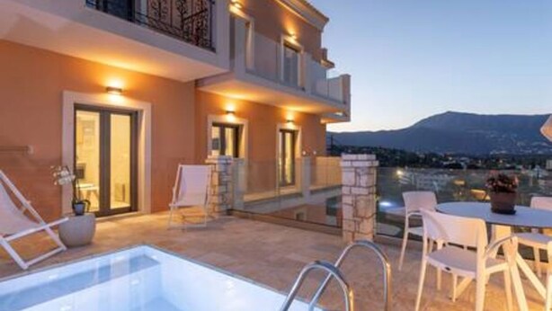 A modern hotel with a pool, outdoor seating, and a view of the city and mountains. - Onore Sunset Suite & pool | Dasia (Dassia)