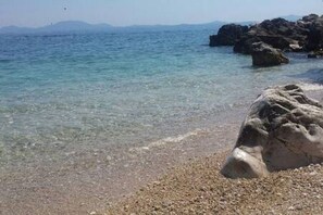 A rocky shoreline with clear water and distant mountains. - Villa Angeliki by Tsiolis family ★ 30m from beach (Katavolos)