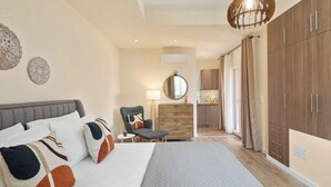 A hotel room with a large bed, a desk, a chair, and a wardrobe. - Achileio Alexandros Cottage (Gastouri)