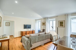 Un salon moderne avec un canapé, une table à manger et un téléviseur.
