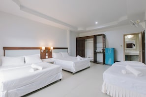 Two single beds with white linens and pillows, a nightstand, and a minibar.
